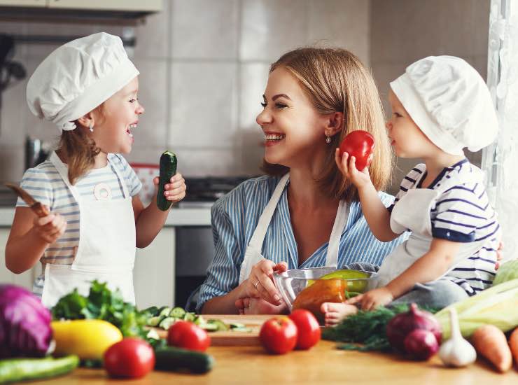 Una mamma cucina con i suoi figli